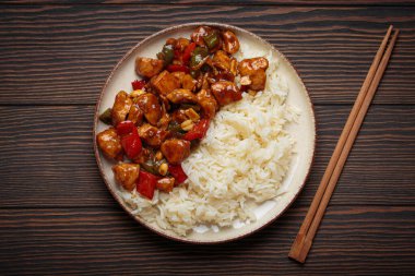 Çin usulü kung pao tavuğu pilav, sebze ve baharatlı soslu fıstık. Ahşap arka planda üst manzara. Öğle veya akşam yemeği için mükemmel.