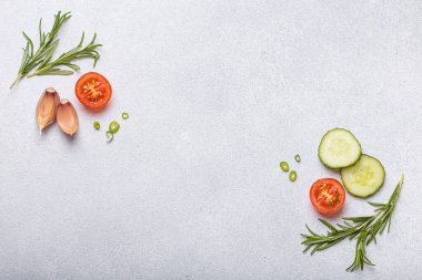Taze kesilmiş sebzeler ve otlar gri arka planda boş bir alanı, sağlıklı ve organik bir yaşam tarzını, yemek pişirme konseptini çerçeveliyorlar.