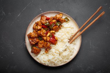 Çin usulü kung pao tavuğu pilav, sebze ve baharatlı soslu fıstık. Koyu arkaplanda üst görünüm. Öğle veya akşam yemeği için mükemmel.