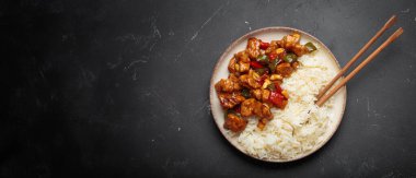 Çin usulü kung pao tavuğu pilav, sebze ve baharatlı soslu fıstık. Koyu arkaplanda üst görünüm. Öğle veya akşam yemeği için mükemmel.