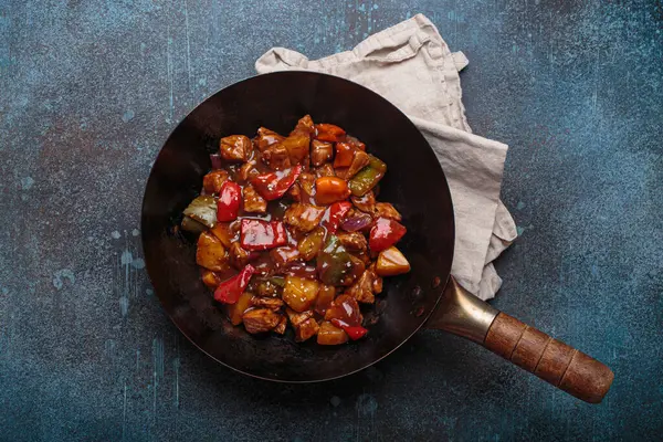 Renkli çan biberleri ve ananas parçalarıyla tavada tatlı ve ekşi domuz eti, klasik Asya yemeği.