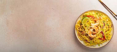 Karides, fıstık, limon ve doğranmış sebzeli Tayland yemeği açık bej arka plan manzaralı çubuklar, Tayland yemeği. Boşluğu kopyala