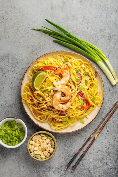 Karides, yer fıstığı, limon, kırmızı dolma biber ve gri soğanlı nefis Tayland eriştesi.