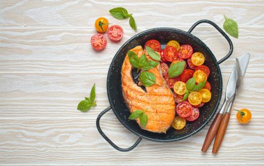 Siyah tavada ızgara somon bifteği, yanında canlı vişne domatesleri ve taze fesleğen yaprakları, sağlıklı beslenme ya da diyet konsepti, kopyalama alanı.