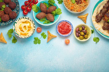 Orta doğu ya da Arap yemeklerinin sınır kompozisyonu ve açık bej arka planda çeşitli mezeler. Et kebabı, falafel, humus, sambusak, pilav, kibbe, pide. Kutsal yiyecekler. Lübnan mutfağı, kopyalama alanı