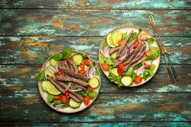 Geleneksel Tayland sığır eti salatası ve sebzeli ve nane soslu, ahşap arka planda servis edilen sağlıklı egzotik Asya yemeği..