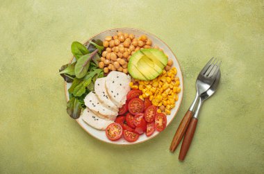 Kızarmış tavuk göğsü, nohut, avokado, mısır ve domatesli sağlıklı bir kase, dengeli ve besleyici bir yemek ve sağlıklı bir yaşam tarzı.