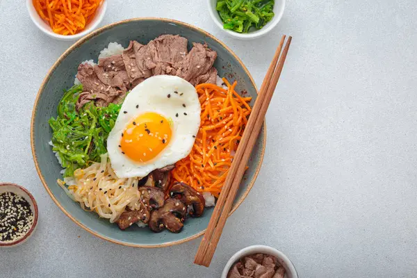 Bibimbap, haşlanmış pirinçli otantik Kore yemeği omlet, sığır eti, renkli sebzeler, açık arkaplanda geleneksel Kore yemeği, kopyalama alanı.