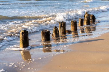 Dalgalar eski ahşap dalgaların kalıntılarına çarpıyor.