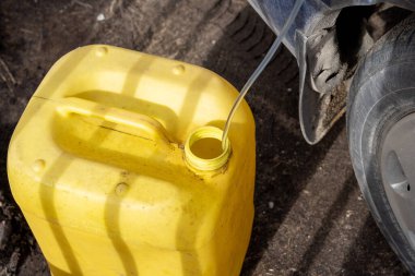 İçinde plastik tüp olan kırmızı benzin bidonu. Arabadan senfoni gazı.