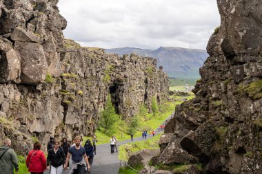 Thingvellir rift vadisi, İzlanda - 06.26.2023: İzlanda 'daki Kuzey Amerika ve Avrasya tektonik plakaları arasında kıta yarığı üzerinde yürüyen turistler