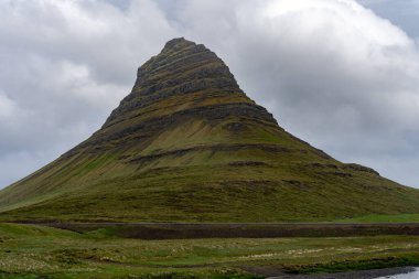 İzlanda 'daki Kirkjufell Dağı, arka planda bulutlu gökyüzü