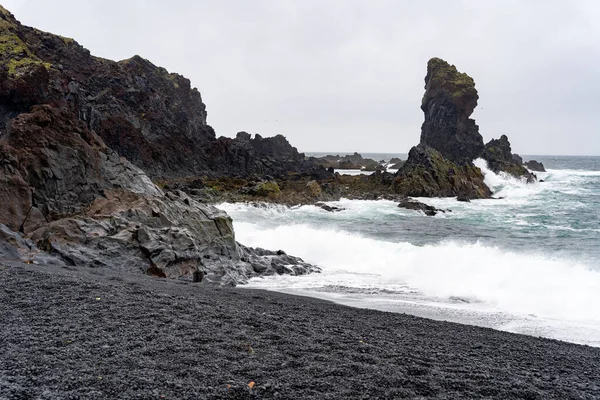 Dalgalar İzlanda 'daki Djupalonssandur kara kumsalına vuruyor.