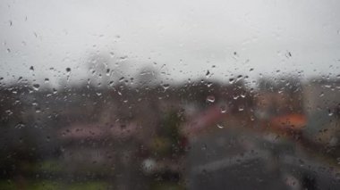 Yağmurlu bir günde pencere camından damlayan yağmur damlaları.
