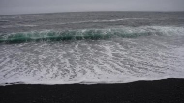 Reynisfjara 'ya vuran dalgaların yavaş çekimleri İzlanda' daki Kara Kum Sahili 'ne vuruyor.