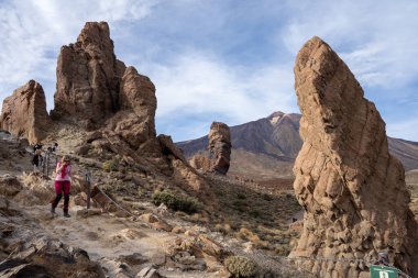 Tenerife, İspanya - 04.12.2023: İnsanlar Teide Ulusal Parkı, Tenerife, Kanarya Adaları, İspanya 'daki Roques de Garcia volkanik kayalarına yürüyüş yapıyor