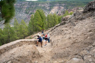 Gran Canaria, İspanya - 05.12.2023: İnsanlar İspanya 'nın Gran Canaria adasındaki Roque Nublo volkanik kayasına doğru yürüyüş yapıyorlar