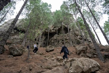 Gran Canaria, İspanya - 05.12.2023: İnsanlar İspanya 'nın Gran Canaria adasındaki Roque Nublo volkanik kayasına doğru yürüyüş yapıyorlar
