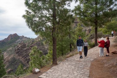 Gran Canaria, İspanya - 05.12.2023: İnsanlar İspanya 'nın Gran Canaria adasındaki Roque Nublo volkanik kayasına doğru yürüyüş yapıyorlar