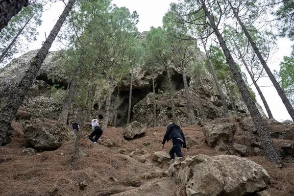Gran Canaria, İspanya - 05.12.2023: İnsanlar İspanya 'nın Gran Canaria adasındaki Roque Nublo volkanik kayasına doğru yürüyüş yapıyorlar