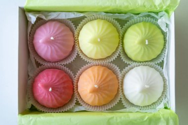 Zefir şeklinde renkli soya mumları bir kutuda.