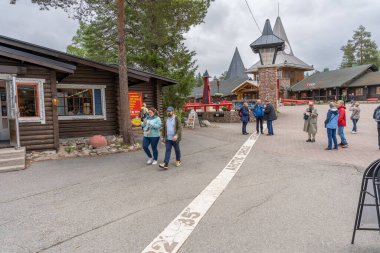 Rovaniemi, Finlandiya - 07.01.2024: Noel Baba Köyü 'ndeki Kuzey Kutup Dairesi geçidinde turistler