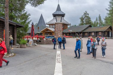 Rovaniemi, Finlandiya - 07.01.2024: Noel Baba Köyü 'ndeki Kuzey Kutup Dairesi geçidinde turistler