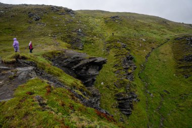 Skarsvag, Norveç - 07.03.2024: Norveç 'te Kirkeporten' e giden bir patikada kayalıklardaki turistler
