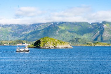 Landscape of small ship in Gimsoystraumen strait in the Lofoten islands, Norway clipart