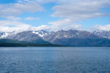 Snowy mountains, fjord and blue sky in Norwegian landscape in Olderdalen, Norway clipart