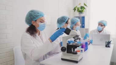 Medical Development Laboratory: portrait of a beautiful african american woman, Scientist Looking Under Microscope, People do Medicine, Biotechnology Research in Advanced Lab