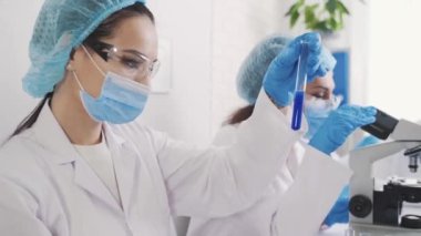 a team of multinational laboratory technicians conducts medical research