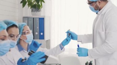 a team of multinational laboratory assistants conducts training, meeting and medical research, african american labrant, blood test, blood test
