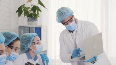 Team of multi national laboratory assistants, African American laboratory assistant conducts training, training in the laboratory, collection of laboratory assistants