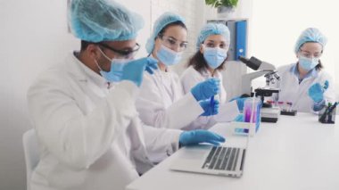 african american laboratory assistant with laptop, teamwork