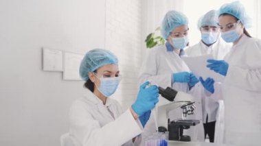 urinalysis in the laboratory, a container with a urine test, a female laboratory assistant of Asian appearance