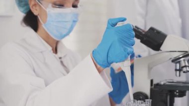 urinalysis in the laboratory, a container with a urine test, a female laboratory assistant of Asian appearance