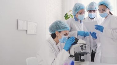Medical Development Laboratory: portrait of a beautiful african american woman, Scientist Looking Under Microscope, People do Medicine, Biotechnology Research in Advanced Lab