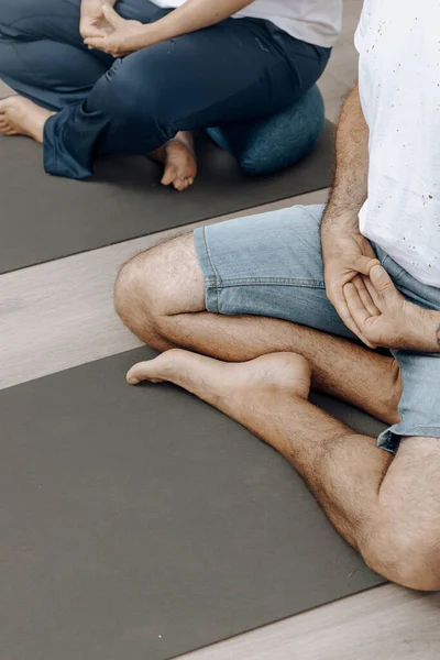Meditasyon yapan insanlar ders sırasında yoga minderlerinde poz verirler.