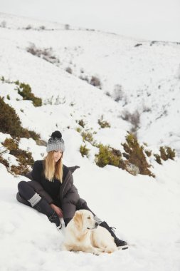 Köpeğiyle karda gülümseyen kadın..