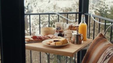 Sıcak Kış Balkon Kahvaltısı: Sanatsal Şarküteri ve Taze Portakal Suyu ile Karlı Ormana Bakan Peynir Tabağı