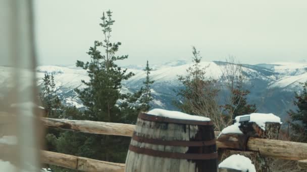 冬のセレニティ エバーグリーンツリーとラスティックな木製レールで囲まれた雪に覆われたマウンテンビュー — ストック動画