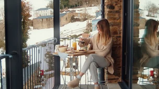 悠闲的冬日清晨 妇女在雪地的阳台上享用自制早餐 乡村背景则是乡村风情 — 图库视频影像