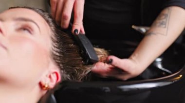 Güzellik salonunda rahatlatıcı bir saç yıkama, profesyonel bakım ve detaylara dikkat çekme. Güzellik hizmetleri ve kişisel bakım programları için mükemmel..