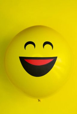 Sarı tonlarda büyük bir gülümseme ile bir balon, ortasına yerleştirilir ve dikey olarak yapılır