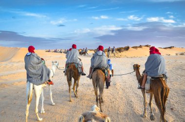Group of tourists riding on camels. Sahara desert, Douz, Tunisia, Africa