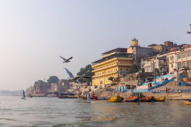 Varanasi, Uttar Pradesh, Hindistan - Kasım 2022: Ganj nehri boyunca antik tapınakları ve binaları olan tarihi Varanasi şehri