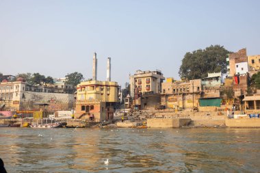 Varanasi, Uttar Pradesh, Hindistan - Kasım 2022: Ganj nehri boyunca antik tapınakları ve binaları olan tarihi Varanasi şehri