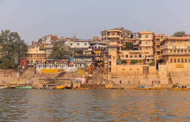 Varanasi, Uttar Pradesh, Hindistan - Kasım 2022: Ganj nehri boyunca antik tapınakları ve binaları olan tarihi Varanasi şehri