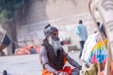 Varanasi, Uttar Pradesh, Hindistan - Kasım 2022: Tanınmayan Hint sadhu baba 'nın portresi gün doğumunda Varanasi şehrinde Ganj nehri kıyısındaki ghat üzerinde.